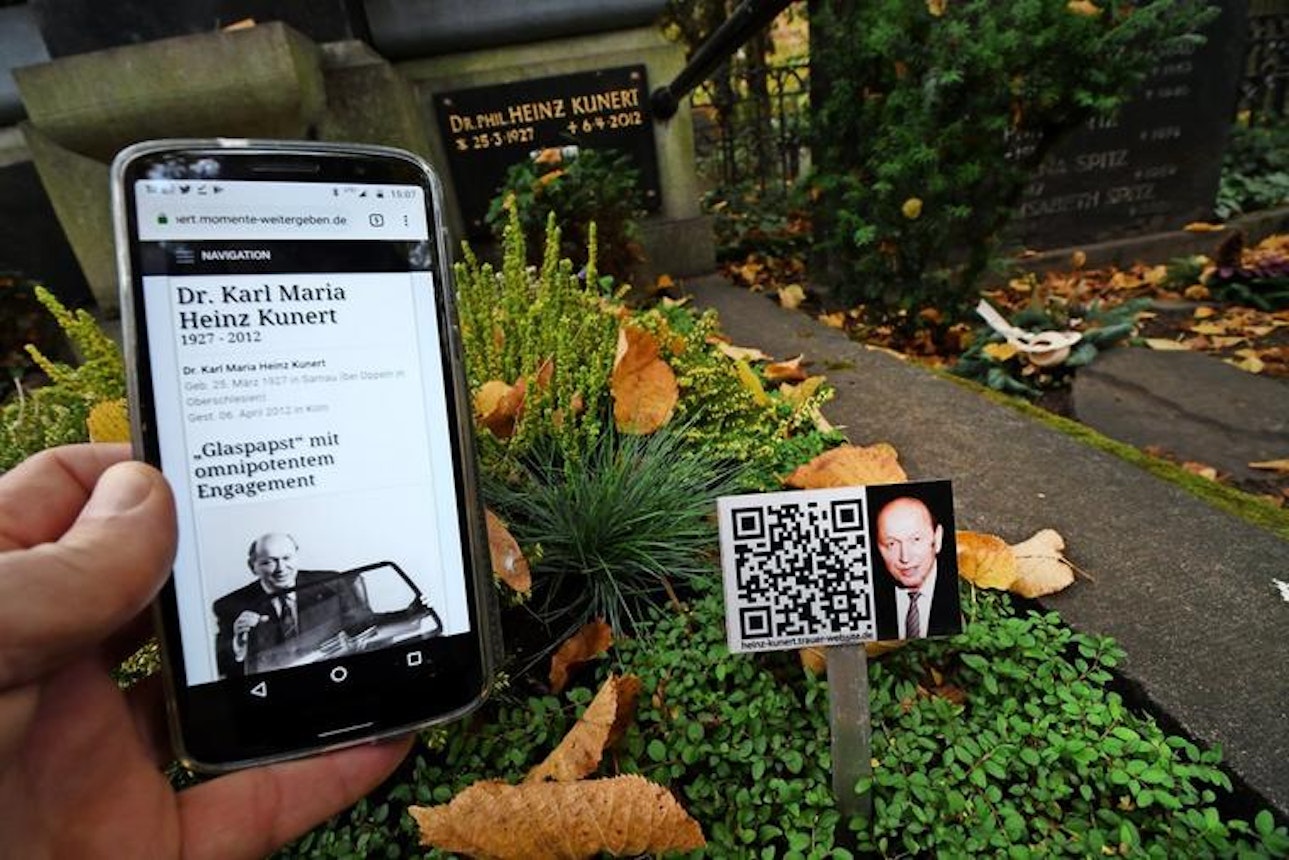 https://bestattungsportal-production.imgix.net/product_images/4551/Eine-Tafel-mit-einem-QR-Code-steht-in-einem-Grab-auf-dem-Friedhof-Melaten-in-Koeln_w760.jpg?ixlib=php-3.3.1